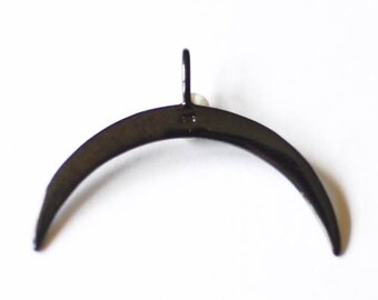 Könnte beinhalten: Ein schwarzer Metall-Halbmond-Anhänger mit einer kleinen Schlaufe oben.