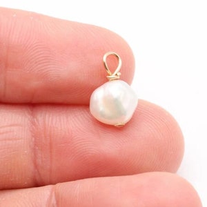 May include: A white baroque pearl pendant with a gold wire loop.