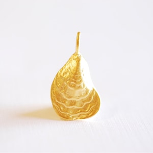 May include: A gold-colored oyster shell pendant charm. The pendant is detailed with a textured surface that resembles the ridges of a real oyster shell.