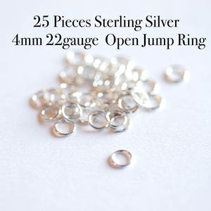 May include: A pile of 25 silver 4mm open jump rings, 22 gauge, on a white surface. 25 Pieces Sterling Silver 4mm 22gauge Open Jump Ring