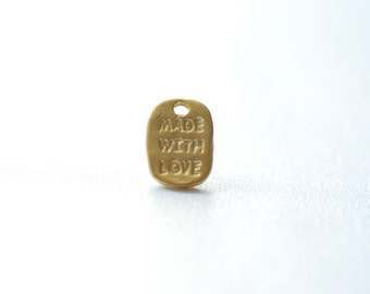May include: Gold-colored metal tag with the words "Made with Love" engraved on it.