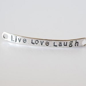May include: Silver charm with the words "Live Love Laugh" engraved on it.