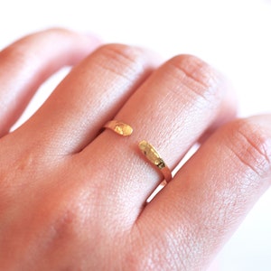 May include: A gold hammered open ring with a textured finish.
