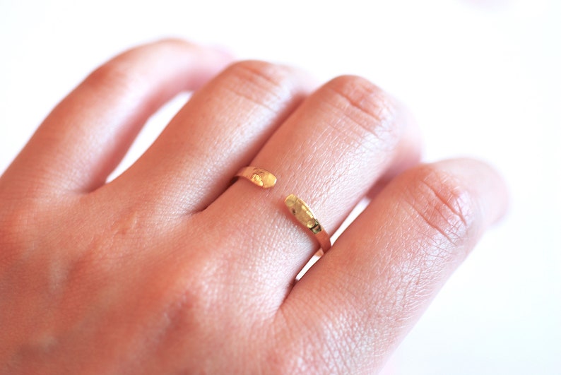 May include: A gold hammered open ring with a textured finish.