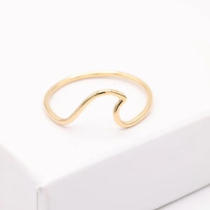 Peut inclure: Une bague en or en forme de vague. La bague est de conception simple avec une bande fine et une forme de vague.