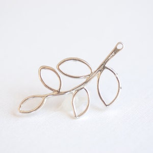 May include: Silver leaf branch pendant with five open leaves. The branch has a loop at the top for attaching to a chain or cord.