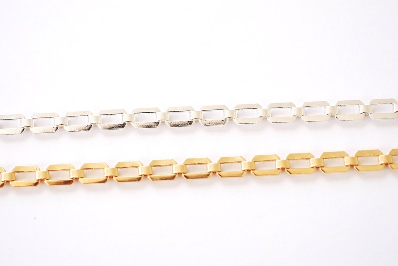 Puede incluir: Dos cadenas, una plateada y otra dorada, con un dise&ntilde;o de eslabones cuadrados. Las cadenas est&aacute;n dispuestas una al lado de la otra sobre un fondo blanco.