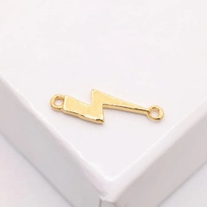 以下が含まれることがあります： 2つのジャンプリングが付いた稲妻の形をした金色の金属製チャーム