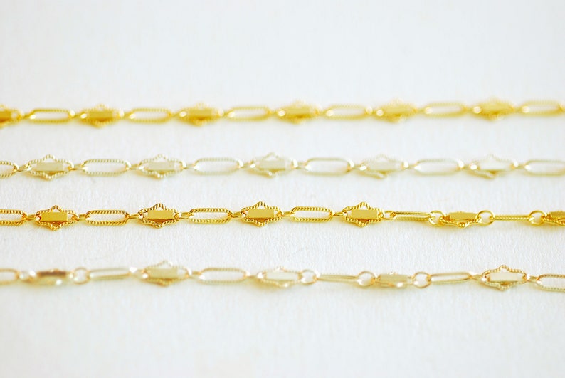 May include: Four gold chains with a decorative, patterned design. The chains are arranged in a row, with the top chain being the longest and the bottom chain being the shortest.