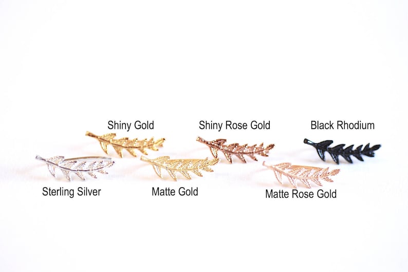 May include: Seven leaf-shaped earrings in different finishes: sterling silver, shiny gold, matte gold, shiny rose gold, matte rose gold, and black rhodium.