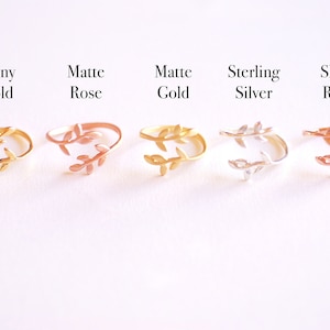 May include: Five adjustable rings with a leaf design. The rings are shown in shiny gold, matte rose gold, matte gold, sterling silver, and shiny rose gold.