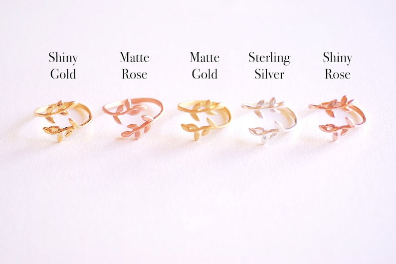 May include: Five adjustable rings with a leaf design. The rings are shown in shiny gold, matte rose gold, matte gold, sterling silver, and shiny rose gold.