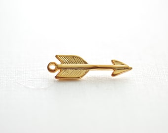 May include: A gold-colored arrow charm with a loop at the top for attaching to jewelry or other crafts.