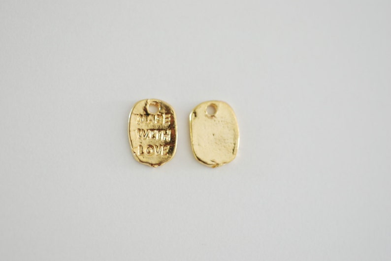 May include: Two gold-coloured metal tags. One tag is blank, the other tag says "Made with Love".