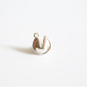 May include: Silver charm in the shape of a fortune cookie.