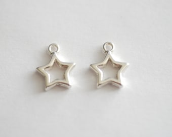 May include: Two silver star-shaped charms with a hole at the top for attaching to jewelry or other crafts.