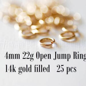 May include: A close-up of 25 gold-filled open jump rings, each measuring 4mm in diameter. The rings are 22 gauge and are ideal for jewelry making.