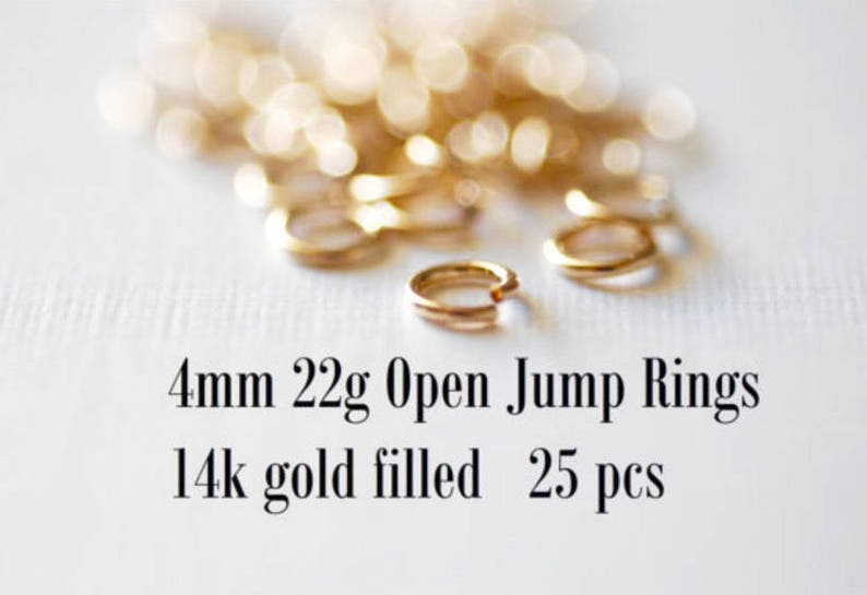 May include: A close-up of 25 gold-filled open jump rings, each measuring 4mm in diameter. The rings are 22 gauge and are ideal for jewelry making.