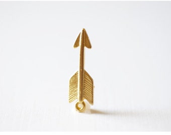 May include: A gold arrow charm with a loop at the bottom. The arrow is detailed with lines to resemble feathers.