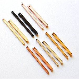 Puede incluir: Surtido de ocho colgantes de barra de metal en varios acabados, incluyendo oro, oro rosa, plata y negro. Cada barra tiene un pequeño agujero en la parte superior para sujetarlo a joyas.