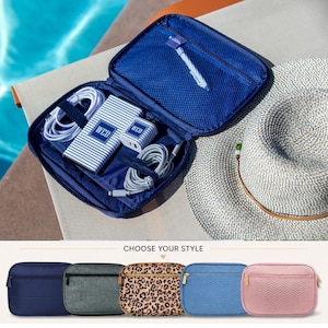 May include: A navy blue travel organizer with a zippered closure, open to reveal a power bank, charger, and cables. The power bank and charger are white with blue stripes and the letters "WED". A straw hat rests nearby. Below are several zippered pouches.