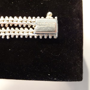 May include: Close-up of a silver bracelet with a clasp that reads "DIAMOND 925 STERLING ITALY".