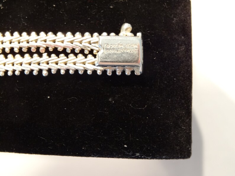 May include: Close-up of a silver bracelet with a clasp that reads "DIAMOND 925 STERLING ITALY".