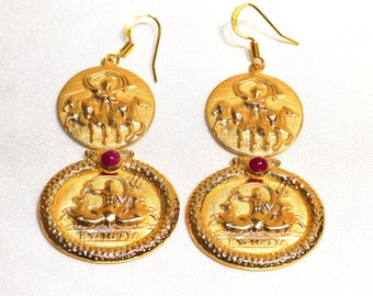 May include: Gold tone earrings with a red stone accent. The earrings feature a circular design with a raised image of a mythological figure riding a chariot.