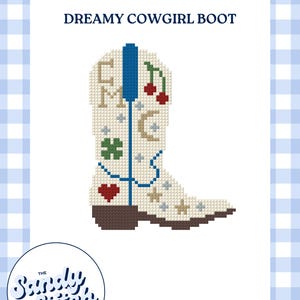 Puede incluir: Un patrón de punto de cruz de una bota vaquera blanca con el texto DREAMY COWGIRL BOOT en la parte superior. La bota está decorada con una trabilla azul, un tacón marrón y varios motivos que incluyen un corazón rojo, un trébol verde, cerezas rojas, una luna creciente y estrellas.
