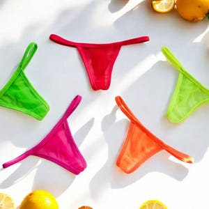 May include: Five pairs of colourful underwear in green, red, pink, and orange. The underwear is made of a sheer fabric and has a simple design.
