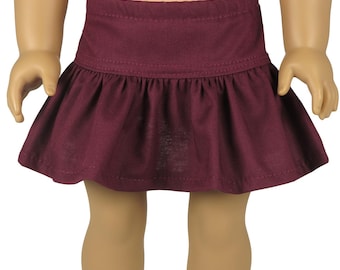 Puede incluir: Una falda de color granate oscuro con una cintura ancha y un dobladillo fruncido. La falda se combina con calcetines blancos con un delicado borde de encaje y zapatos negros de correa en T con un diseño floral recortado en la puntera.