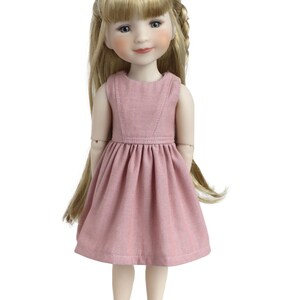 May include: A pink dress with a sleeveless bodice and a gathered skirt. The doll has blonde hair styled in braids and bangs. She is wearing grey shoes.