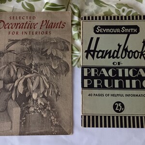 May include: Two vintage books on gardening. The book on the left is titled "Selected Decorative Plants for Interiors" and features a black and white illustration of a plant. The book on the right is titled "Seymour Smith Handbook of Practical Pruning" and has a green cover with black stripes and text.