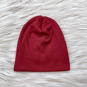 May include: A burgundy ribbed knit beanie hat.