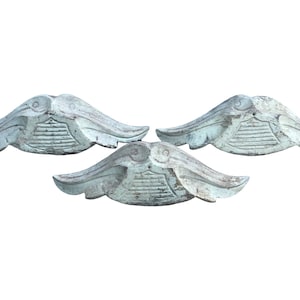 May include: Three white painted wooden decorative pieces with a carved leaf design. The pieces are in the shape of a leaf with a rounded center and a pointed tip.