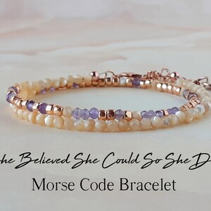 May include: A delicate double-strand bracelet with a message in Morse code. The bracelet features small, light-colored beads and purple beads, interspersed with rose gold beads. The text on the image reads "She Believed She Could So She Did Morse Code Bracelet".