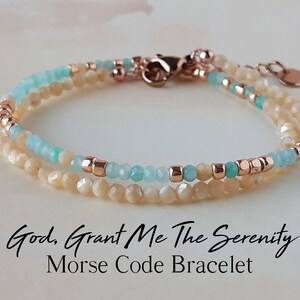 May include: A layered bracelet with small, light-colored beads and accents of turquoise and rose gold. The bracelet features a clasp closure and a small charm. Text on the image reads "God, Grant Me The Serenity Morse Code Bracelet."