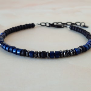 May include: A black and blue beaded bracelet with a silver clasp.