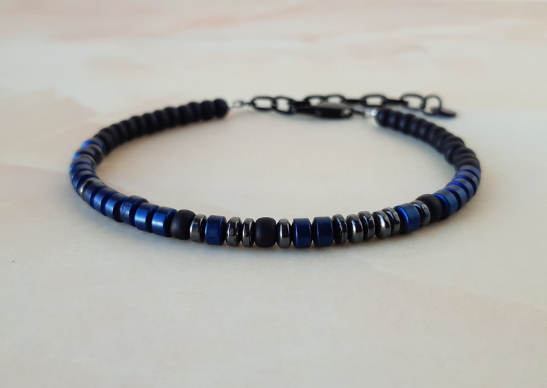 May include: A black and blue beaded bracelet with a silver clasp.