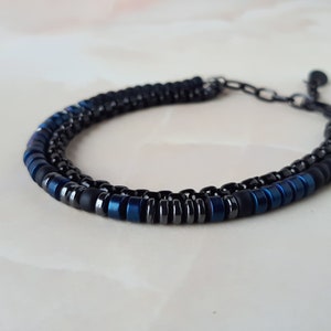 May include: A black and blue beaded bracelet with a silver clasp.