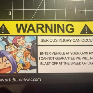May include: A rectangular yellow and white warning sticker featuring an illustration of three cartoon characters from the Pokemon series. The text reads WARNING, SERIOUS INJURY CAN OCCUR, and ENTER VEHICLE AT YOUR OWN RISK I CANNOT GUARANTEE WE WILL NOT BLAST OFF AT THE SPEED OF LIGHT.