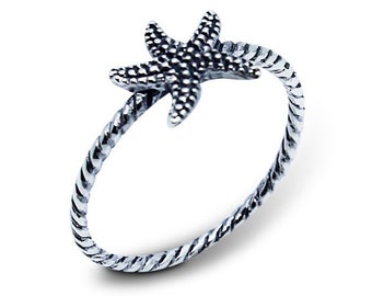 May include: A silver ring with a twisted band and a starfish design.