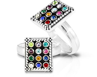 May include: A silver ring with a square-shaped stone set with colorful gemstones. The ring is designed to resemble a traditional Jewish prayer shawl.
