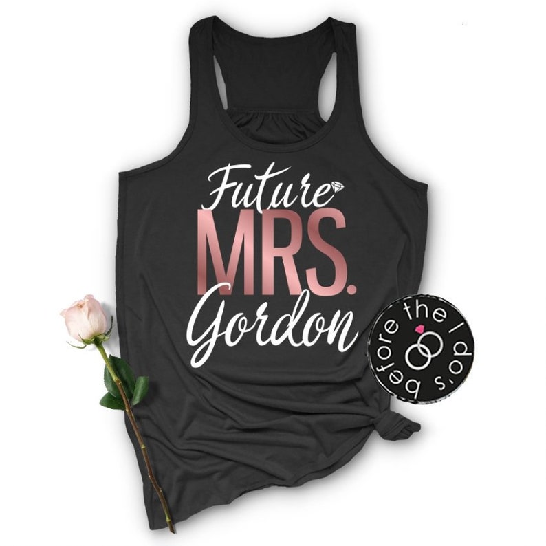May include: Black tank top with the text "Future Mrs. Gordon" in white and rose gold lettering. A diamond symbol is above the word "Future".
