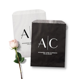 May include: Two wedding favor bags, one white and one black, with the initials "A" and "C" and the names "Amanda and Carson" and the date "06.21.2030" printed on them.