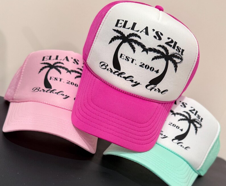 May include: Three pink, white and turquoise trucker hats with black palm tree graphics and the text "Ella's 21st", "Est. 2004", "Birthday Girl" and "Birthday Club".