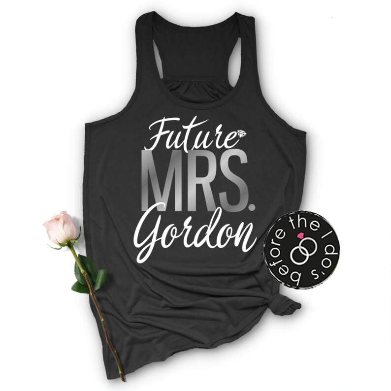 May include: Black tank top with the text "Future Mrs. Gordon" in silver and white lettering. A diamond ring icon is above the word "Mrs."
