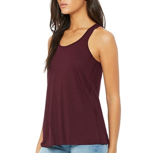 May include: A maroon racerback tank top with a relaxed fit. The tank top is made of a soft, comfortable fabric and has a scoop neck.