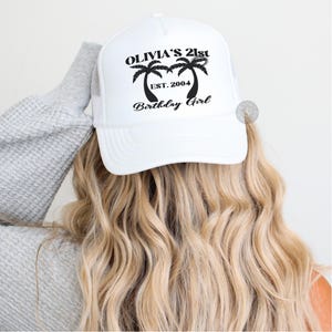 May include: White trucker hat with black text and palm tree graphic that says "Olivia's 21st Est. 2004 Birthday Girl".