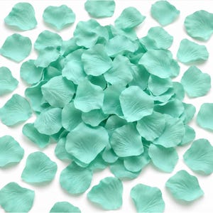 May include: A large collection of artificial mint green rose petals scattered across a plain surface. Each individual petal features a soft, rounded shape with delicate, realistic vein textures visible on the surface of the fabric material.